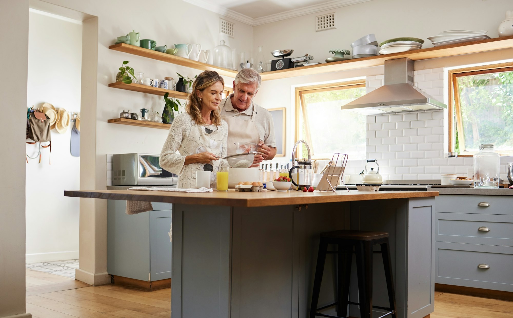 Senior couple in the kitchen cooking together for a party, dinner or lunch in their modern home. Fu